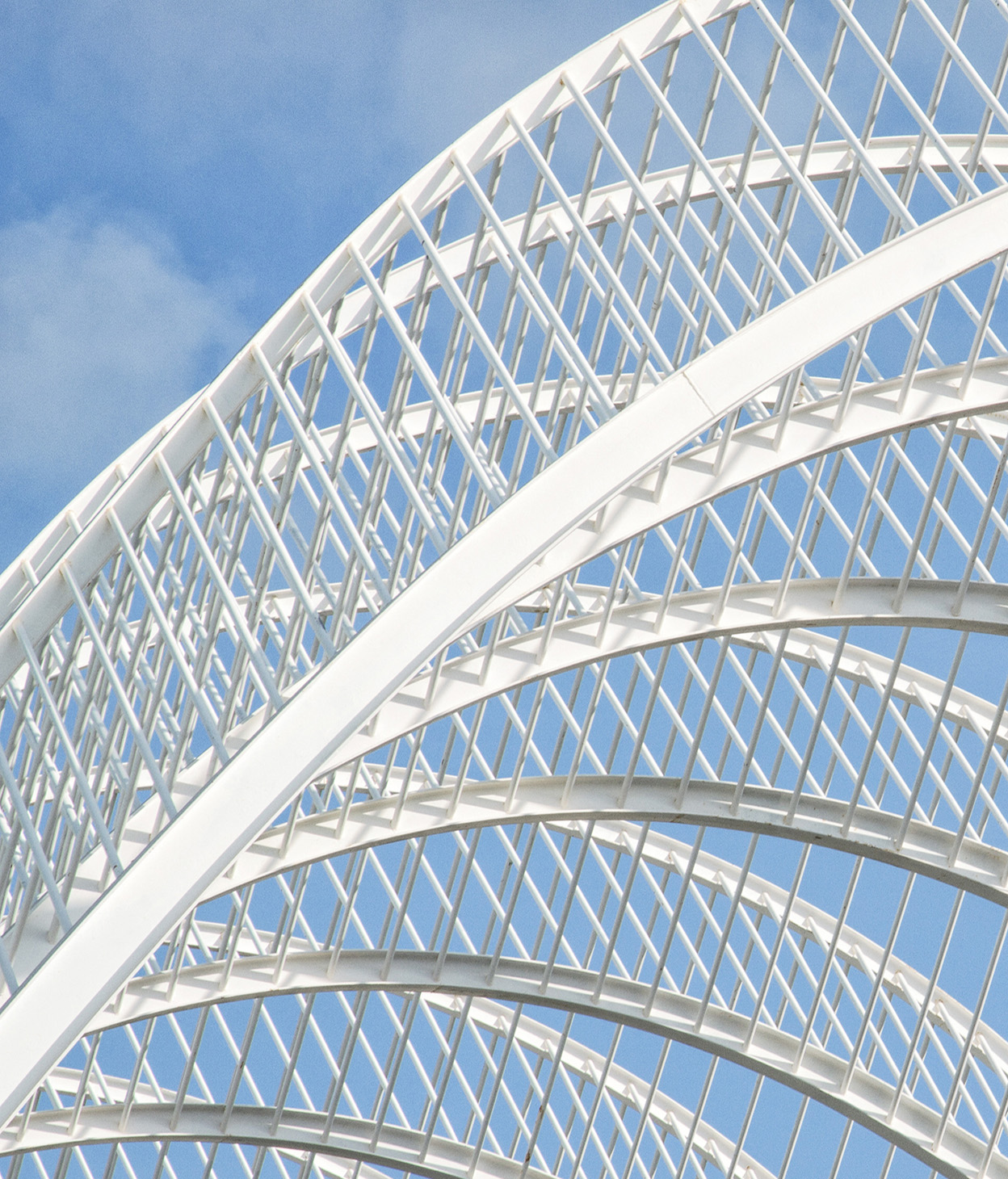 Foto de uma estrutura de arcos metálicos contra um céu azul