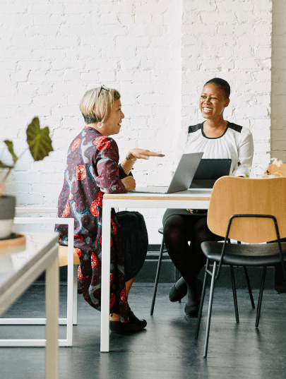 Photo of two women having a discussion in a break room.